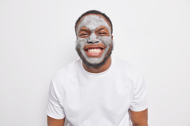 Free photo indoor shot of joyful afro american man grins at camera