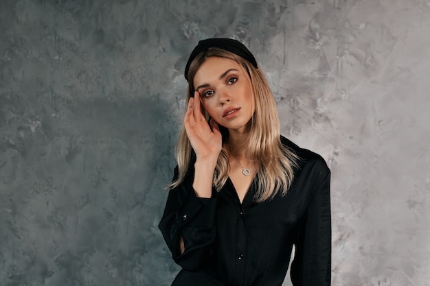 indoor shot of lovely woman in black posing at camera