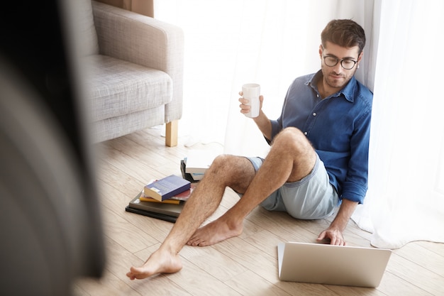 Indoor shot of male nerd student spend all time studying