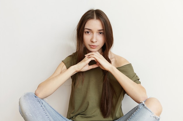 汚い黒髪と悲しい気持ちで美しい微妙な笑顔のかわいい10代の少女の屋内撮影