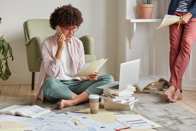 Indoor shot of outraged businesswoman shouts at colleague via cell phone