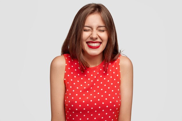 Indoor shot of pleasant looking pleased young European woman with joyful expression