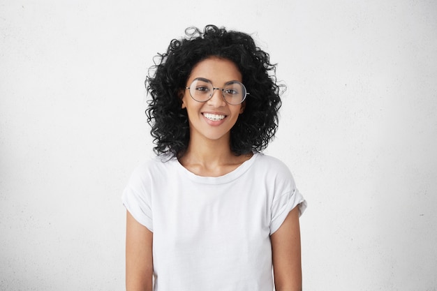 Tiro al coperto di una bella studentessa con un ampio sorriso carino