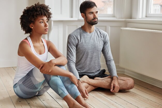 Indoor shot of relaxed couple posing in her home