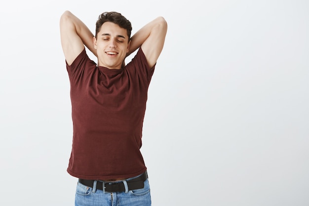 Indoor shot of relaxed good-looking young male model in red t-shirt