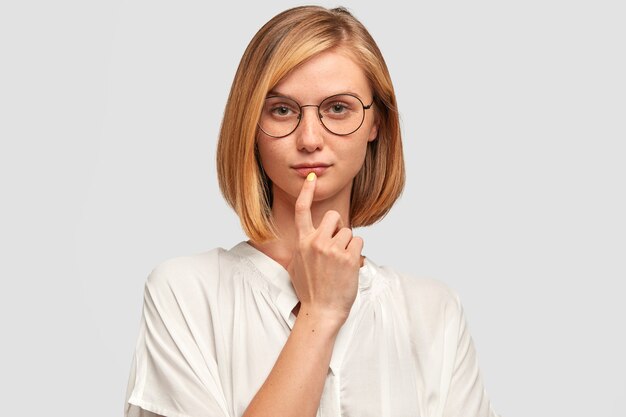 Indoor shot of serious self assured woman contemplates about future plans, wants to change job position