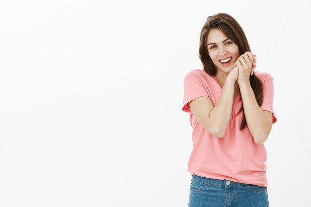 Indoor shot of touched and pleased brunette woman posing in the studio