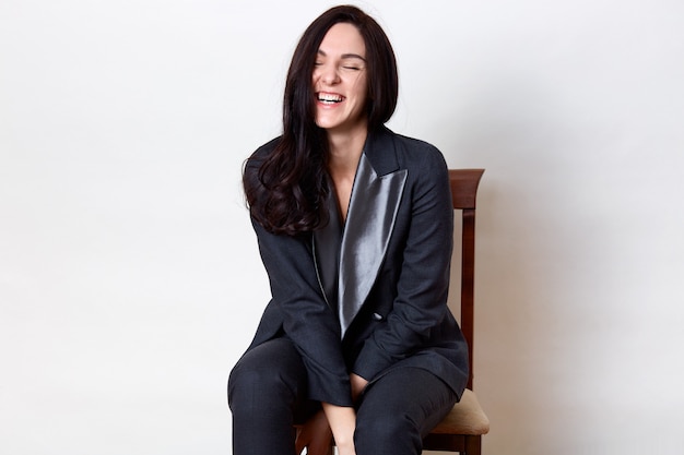 Free photo indoor shot of woman sitting on wooden table and laughing