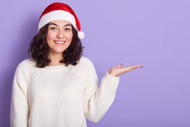 Indoor studio shot of pleasant good looking brunette raising hand