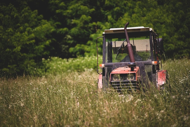 Промышленный трактор, режущий траву на поле