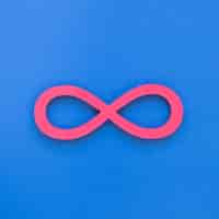 Бесплатное фото Бесконечный розовый символ на синем фоне