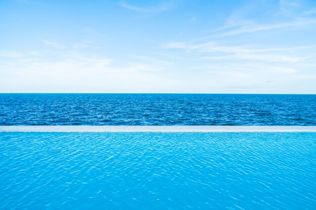 Infinity swimming pool with sea and ocean view on blue sky