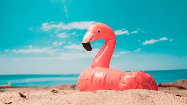 Надувная игрушка розового фламинго на пляже