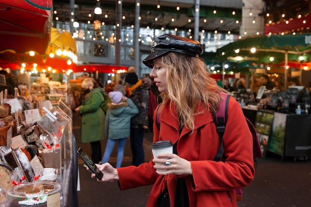 Foto gratuita influencer che scatta foto di una torta al mercato