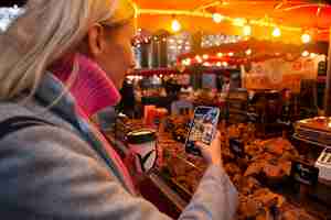 Free photo influencer taking photo of sweets at the market