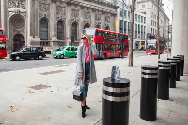 Influencer taking a selfie using a smartphone placed on a pylon in the city