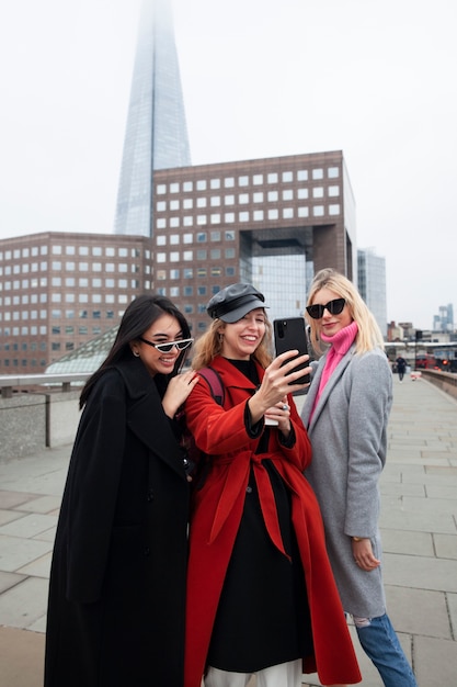 Foto gratuita influencer che si fanno un selfie su un ponte della città