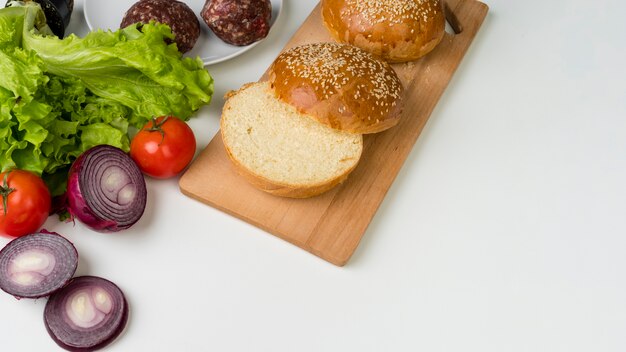 Ingredients for delicious burger on white table