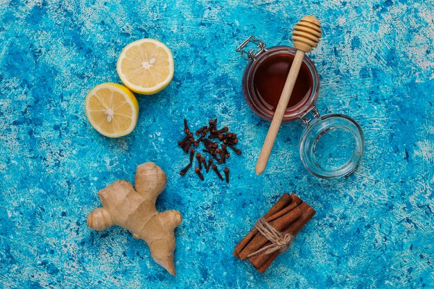 Ingredients: fresh ginger, lemon, cinnamon sticks, honey, dried cloves for making immunity boosting healthy vitamin drink