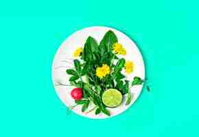 Free photo ingredients for a fresh green salad with dandelions and edible flowers on a plate