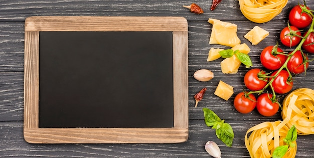 Ingredients for italian food with chalkboard beside