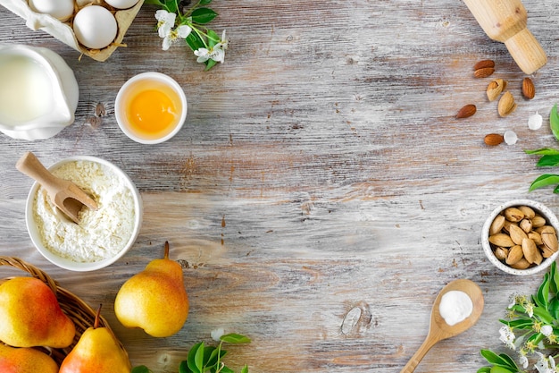 Ingredients for making buns or pies with jam and fresh pears on a wooden background Top view Copy Space