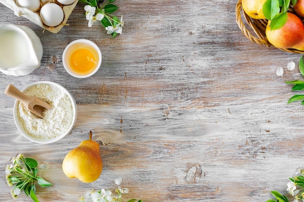 Ingredients for making buns or pies with jam and fresh pears on a wooden background Top view Copy Space