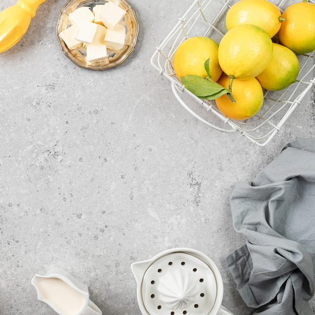 Ingredients for making a pie with lemon curd and blueberries on a white stone table Square