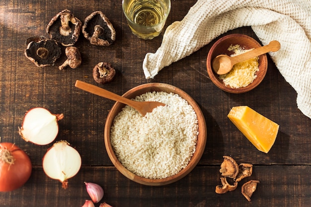 Ingredients for making risotto fungi on rustic wooden table