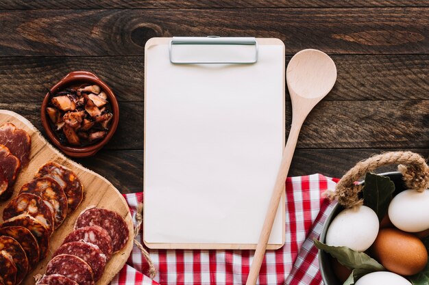 Ingredients and napkin near spoon and clipboard