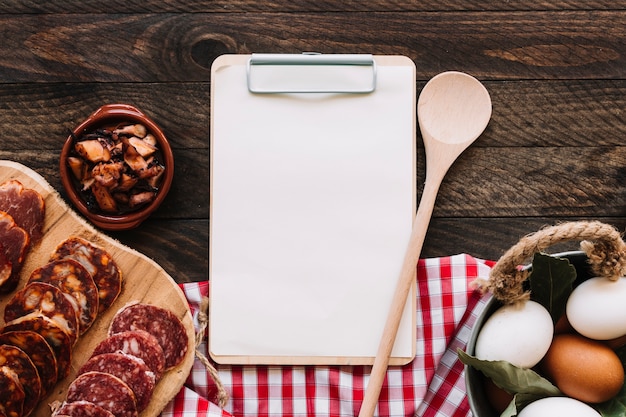 Ingredients and napkin near spoon and clipboard