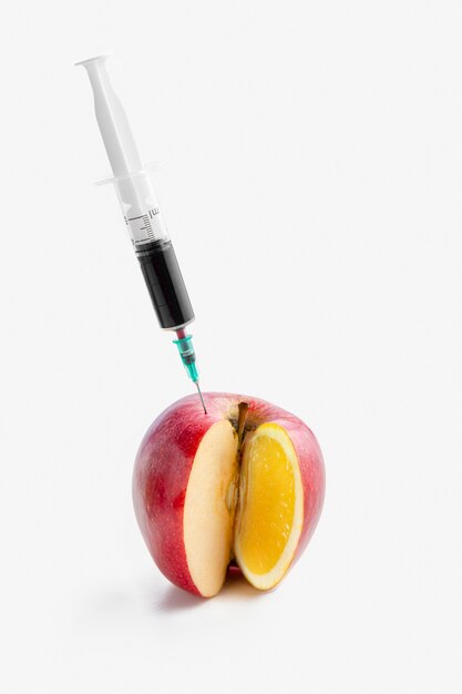 Injecting chemicals into an apple with syringe