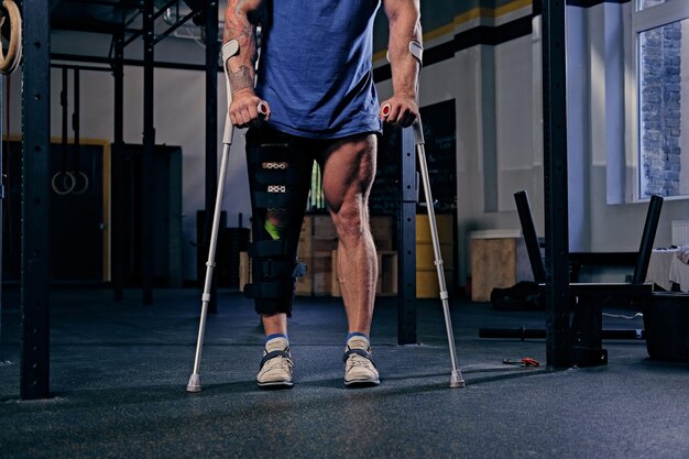 Injured bodybuilder's leg in bandage with crutches.