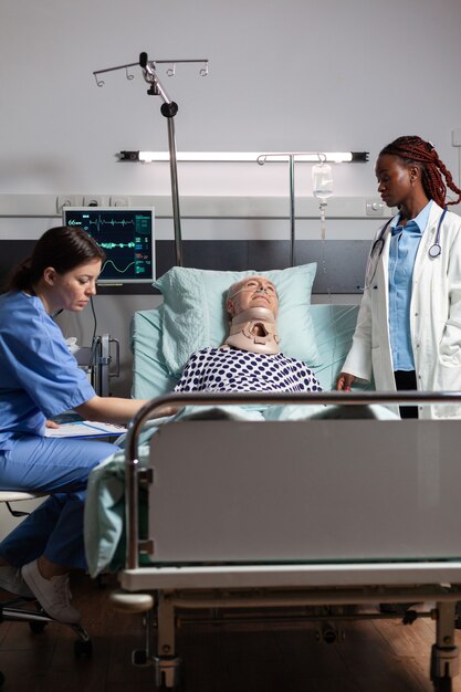 Injured senior man with neck brace laying in bed