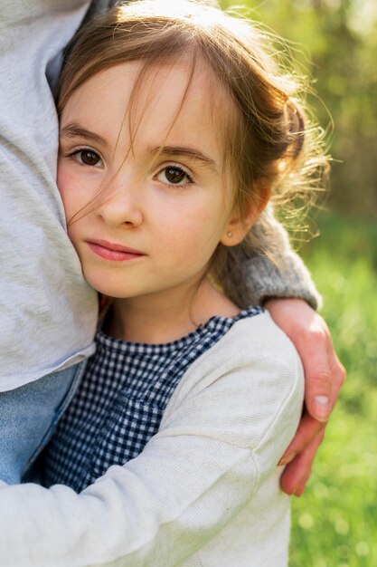 Innocent girl hugging mother close up