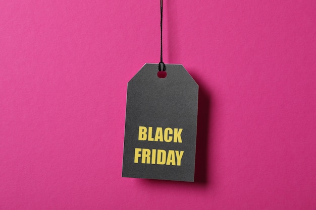 Inscription black friday on price tag on pink space, copy space