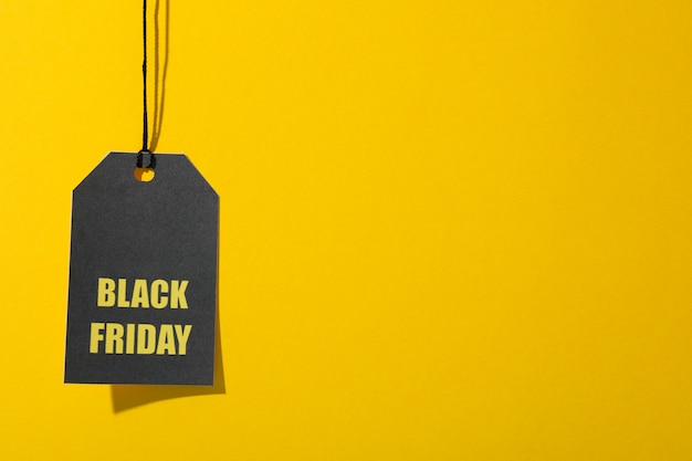 Inscription black friday on price tag on yellow space, copy space