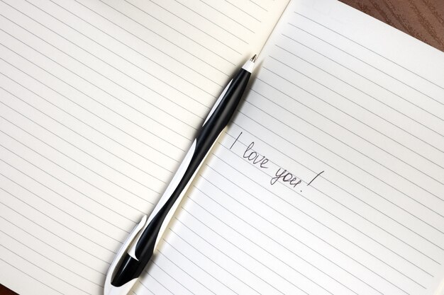 Inscription i love you written on lined notepad