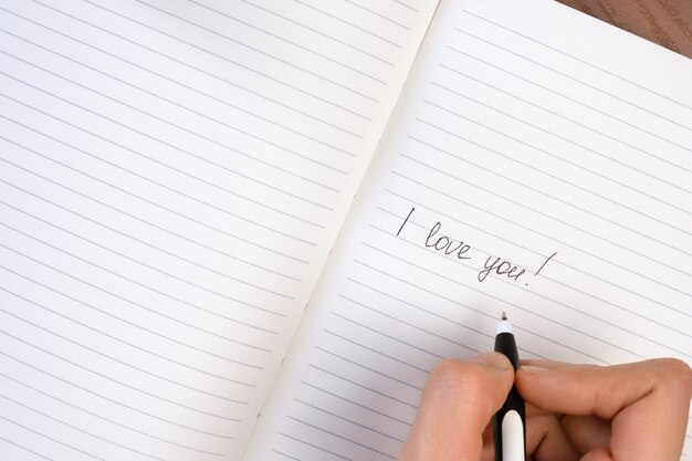 Inscription i love you written on lined notepad