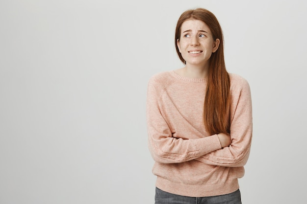 Free photo insecure anxious redhead female student looking away in panic