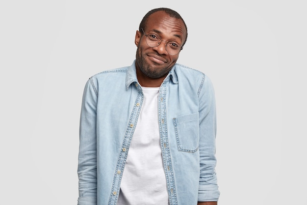 Insecure hesitating stressed black man looks clueless at camera, shrugs shoulders