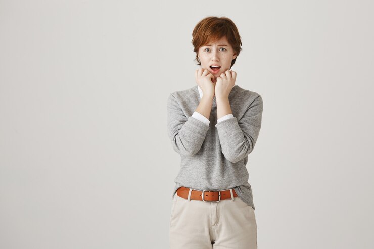 무료 Photo 짧은 머리가 흰 벽에 포즈를 취하는 안전하지 않은 걱정 빨간 머리 소녀