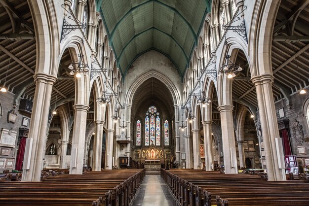 Inside view of a church with religious icons on the windows and stone arches