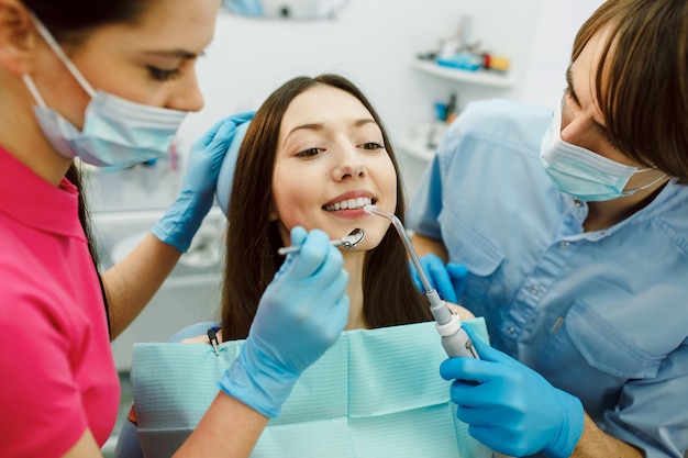 Free photo inspection of the teeth of the woman with the help of a mirror.