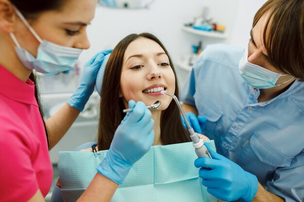 거울의 도움으로 여성의 치아 검사.