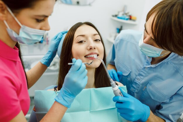 Inspection of the teeth of the woman with the help of a mirror.