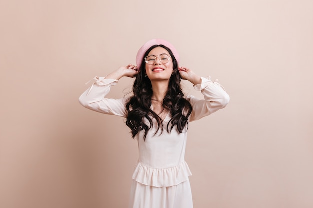 Inspired chinese lady posing in beret. Front view of blithesome asian girl in trendy outfit.