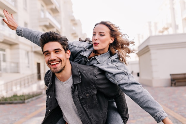 Ragazza bionda ispirata che gode della passeggiata con il fidanzato. adorabile signora trascorrere del tempo con il marito all'aperto.