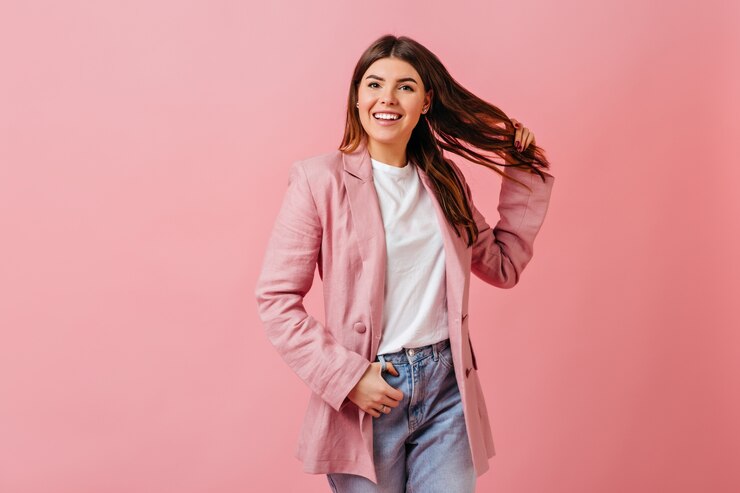 Free Photo inspired lady playing with hair and smiling. studio shot of girl in casual attire isolated on pink background.