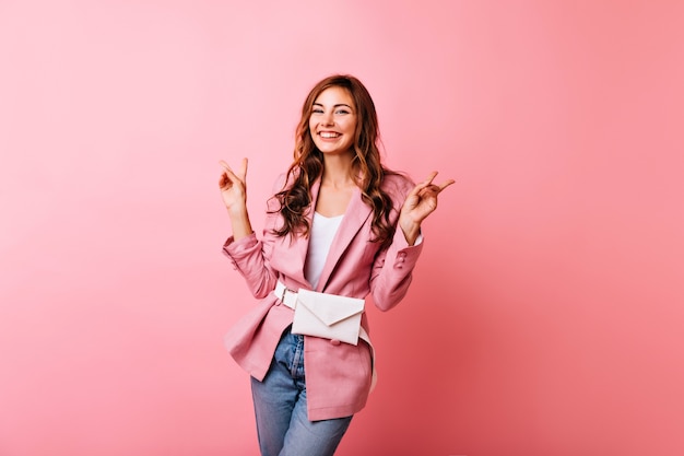 Foto gratuita la ragazza snella ispirata si diverte. incredibile signora caucasica in giacca rosa sorridente